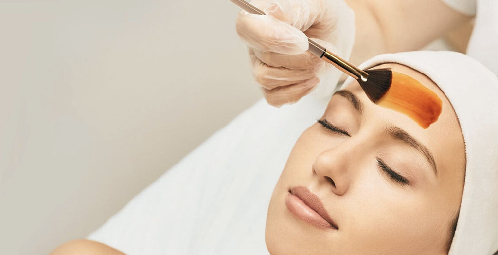 client receiving facial with mini brush painting product on skin